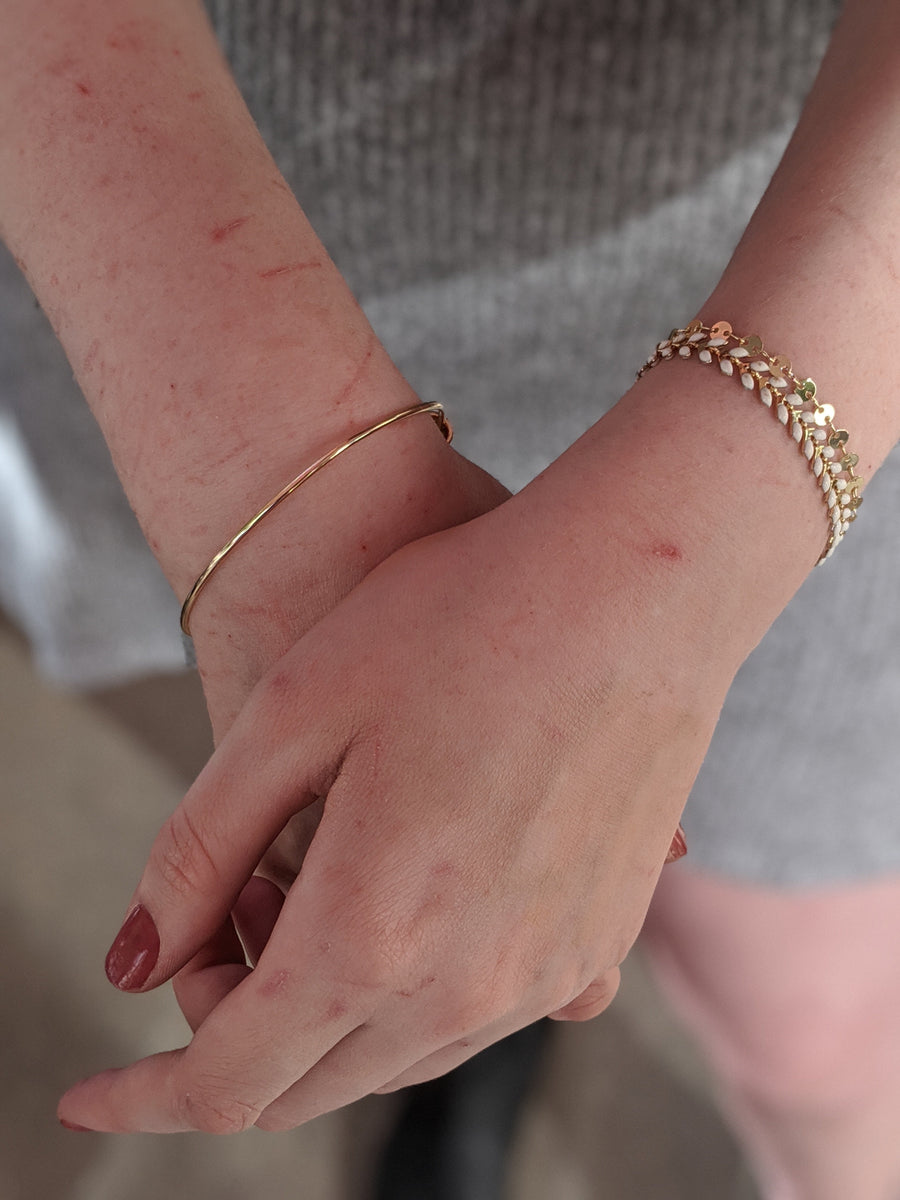 woman wearing gold and white layering bracelets rose burkhardt jewelry online shop