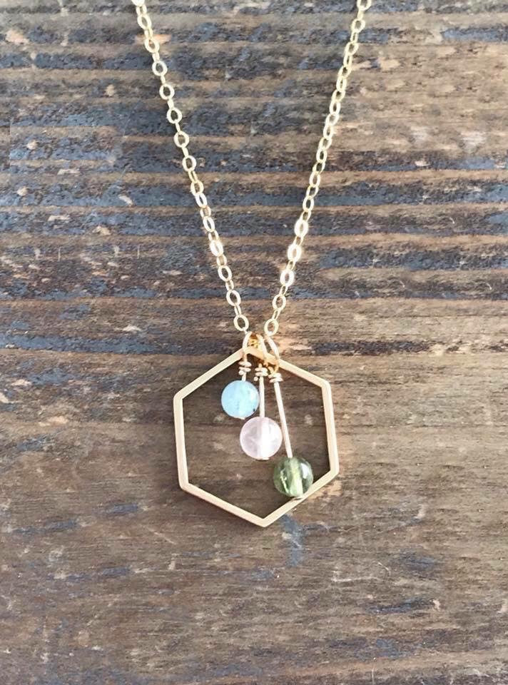 Personalized birthstones suspended in gold hexagon
